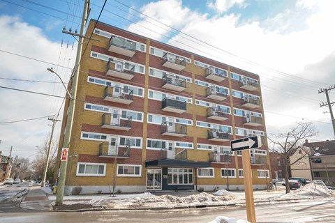 A large multi-story building with a yellow and red facade.