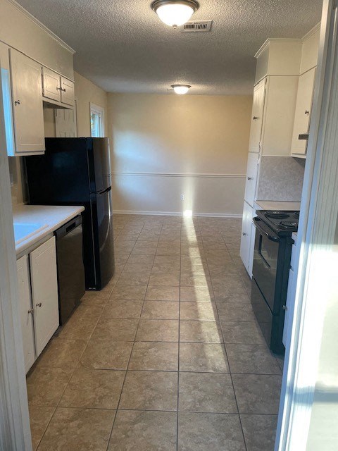 a kitchen with a stove and a black refrigerator
