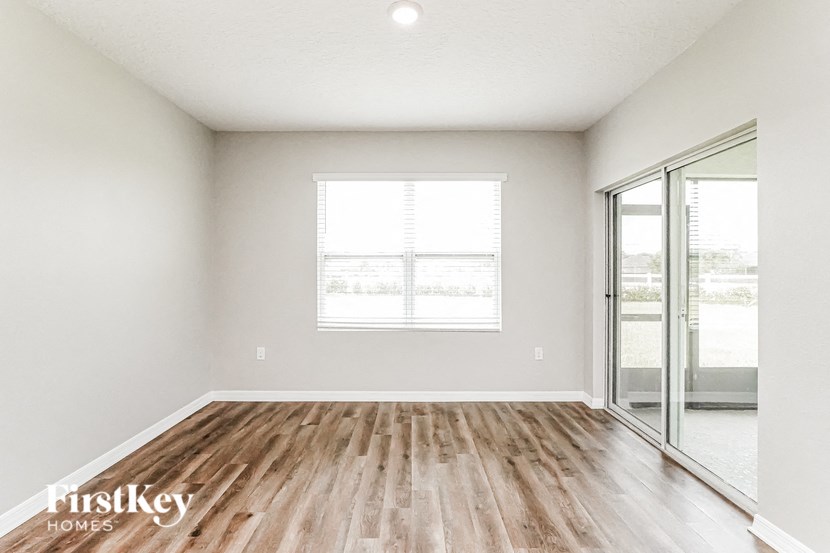 A room with wooden flooring and a sliding glass door.