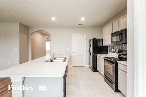 A kitchen with a white countertop and black appliances.