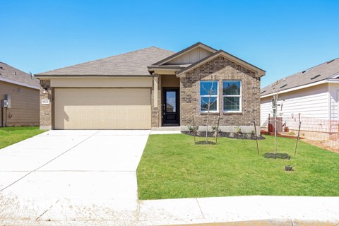 a house with a lawn and a sidewalk in front of it