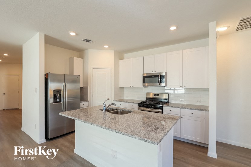 a kitchen with white cabinets and a granite counter top
