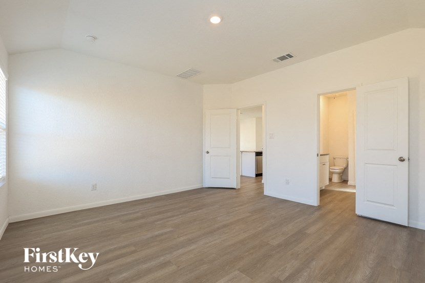 an empty living room with white walls and wood flooring