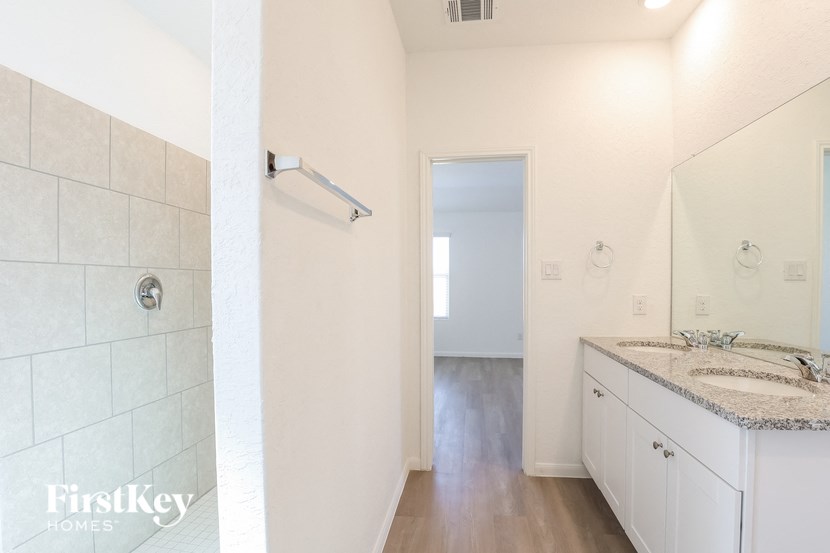 a bathroom with a shower and a sink and a mirror