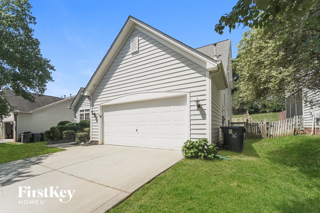 A house with a garage and a driveway in front of it.