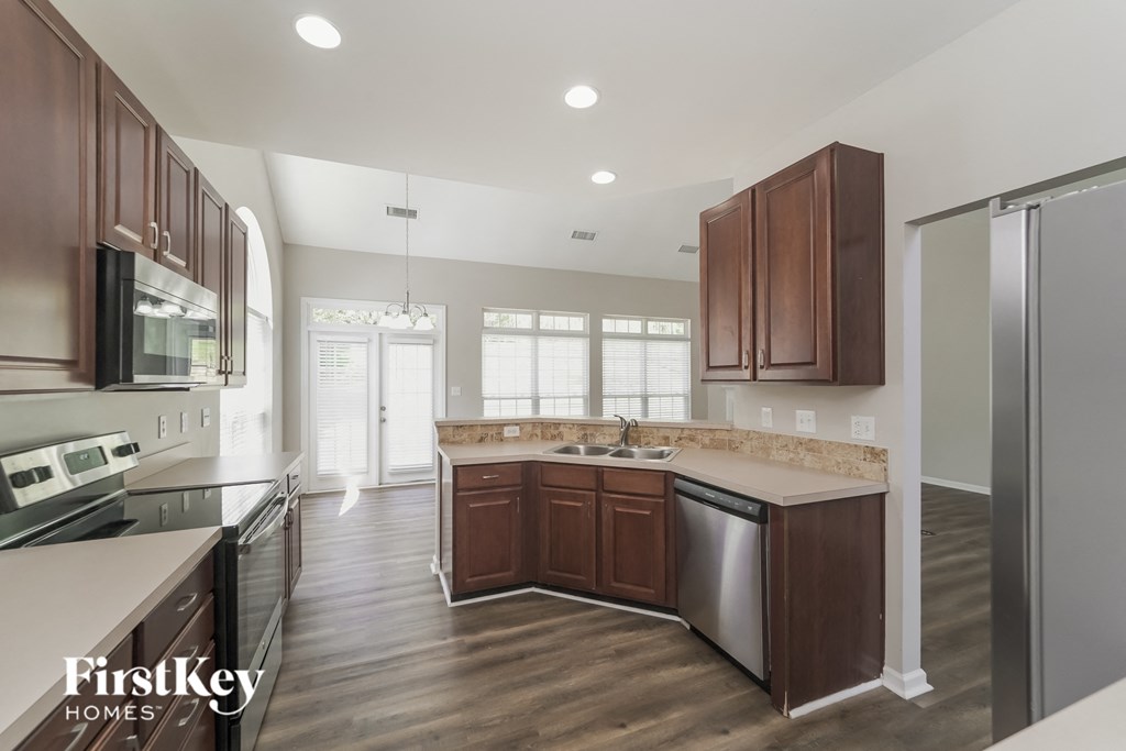 A kitchen with brown cabinets and a stainless steel dishwasher.