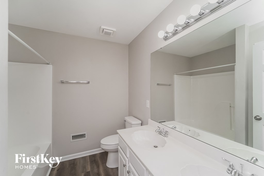 A bathroom with a white sink and mirror.