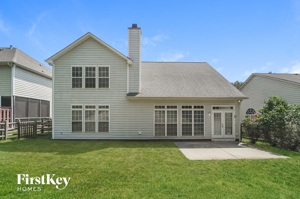 A house with a white exterior and a grey roof is for sale by FirstKey Homes.