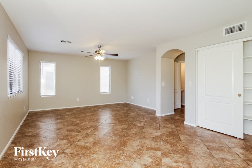 A spacious room with a fan and tiled flooring.