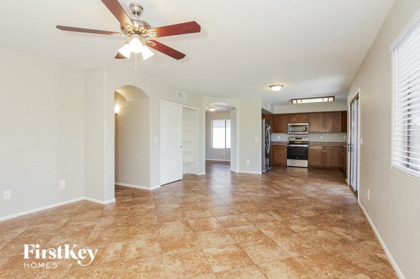 A spacious room with a ceiling fan and tiled flooring.