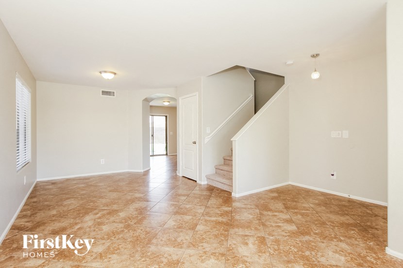 A spacious empty room with a staircase leading to the upper floor.