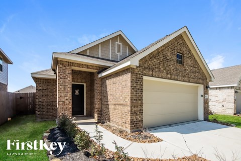 A brick house with a garage door is for sale.
