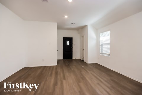 A room with wooden flooring and a black door.