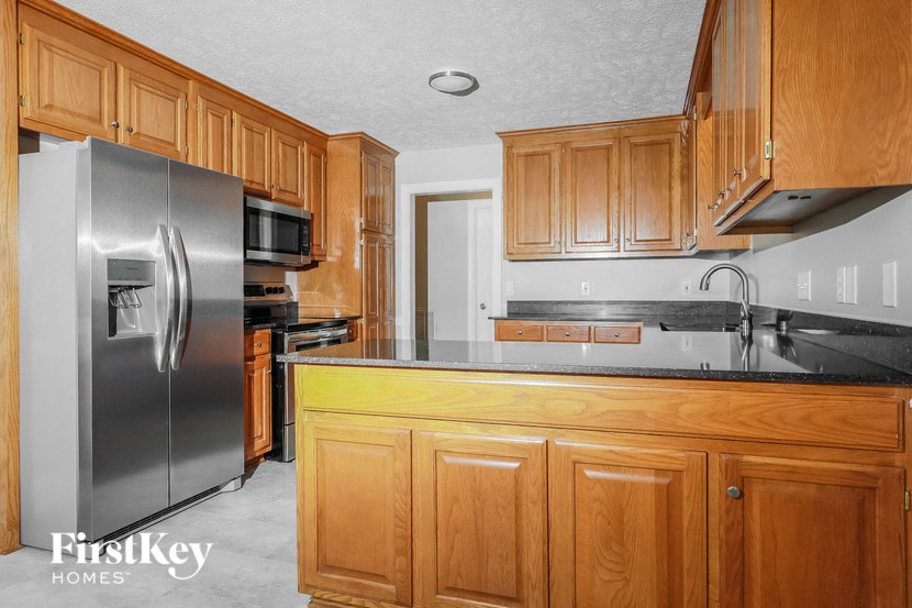 a kitchen with wooden cabinets and a stainless steel refrigerator