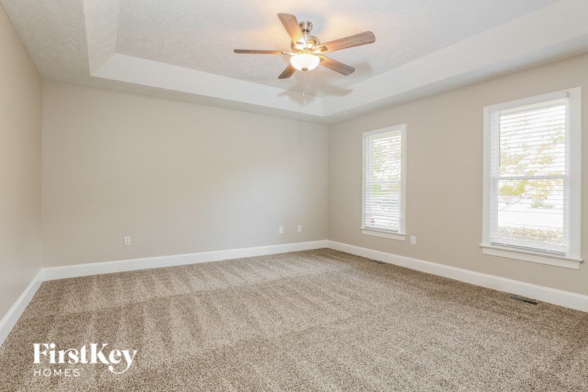 an empty living room with a ceiling fan
