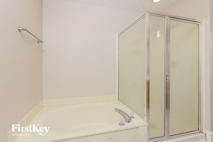 a white bathroom with a shower and a bath tub