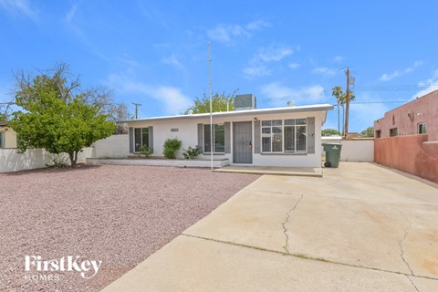 A house with a white exterior and a grey roof is for sale.