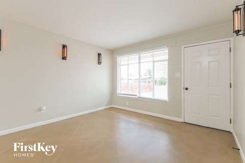 A room with a white door and two wall sconces.