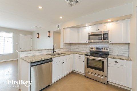 A kitchen with white cabinets and stainless steel appliances.