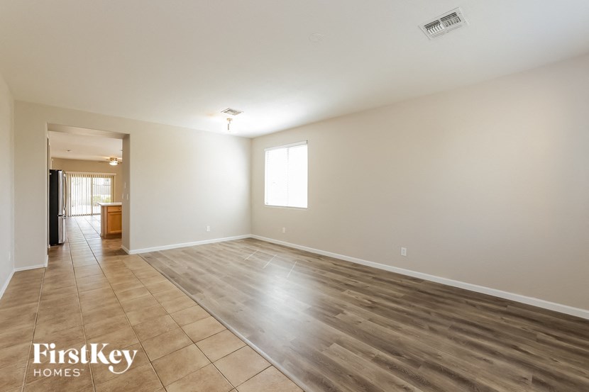 A spacious room with wooden flooring and a large window.