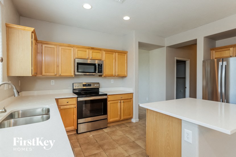 A kitchen with wooden cabinets and a stainless steel refrigerator.