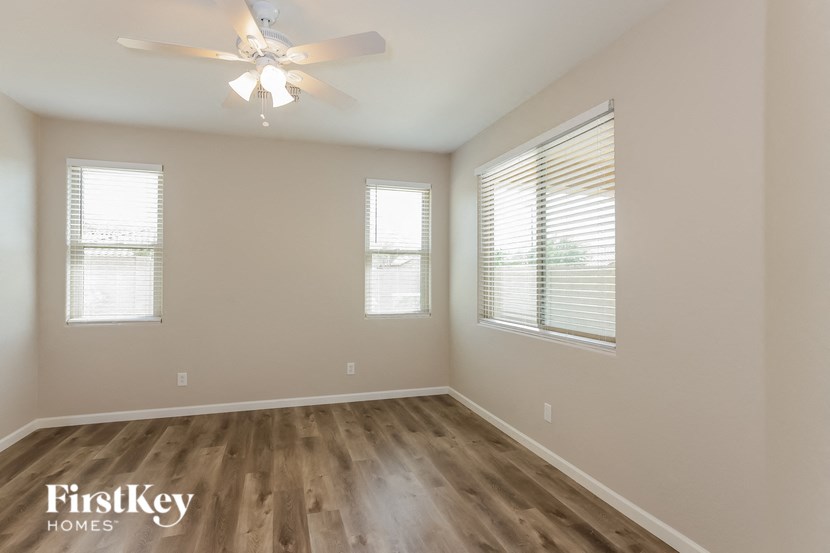 A room with wooden floors and a ceiling fan.