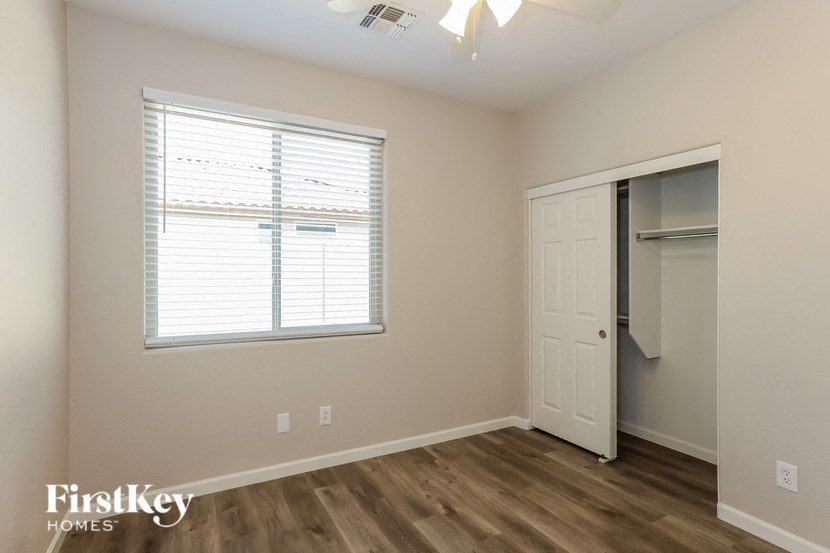 A room with a white door and a window with blinds.