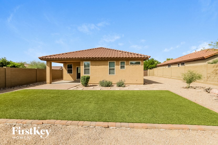 A house with a brown roof and a green lawn in front.
