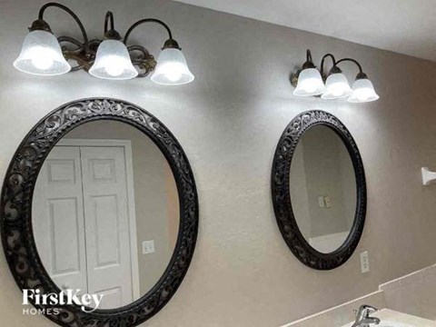 A bathroom with a mirror and lights above it.