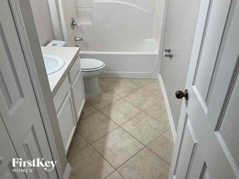 A bathroom with a toilet, sink, and bathtub.