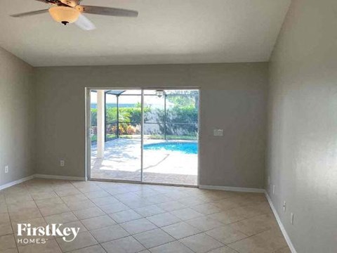 A room with a sliding glass door leading to a pool.