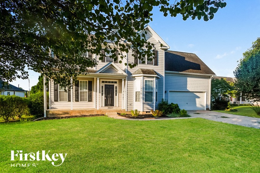 a blue and white house with a lawn and a driveway