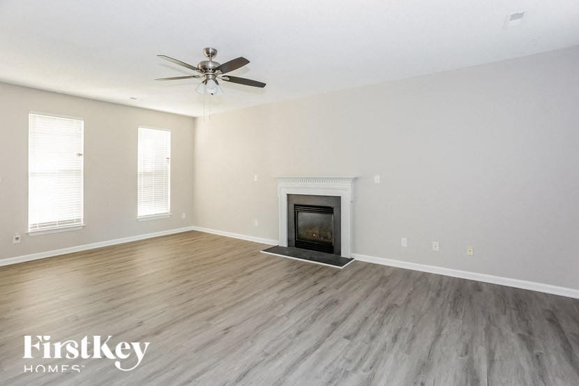 a living room with a fireplace and a ceiling fan