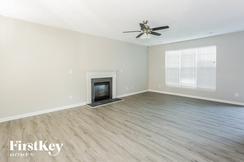a living room with a fireplace and a ceiling fan