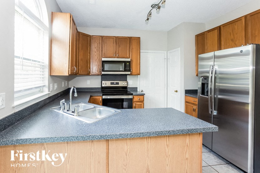 a kitchen with a blue counter top and a stainless steel refrigerator