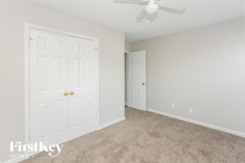 a bedroom with two closets and a ceiling fan