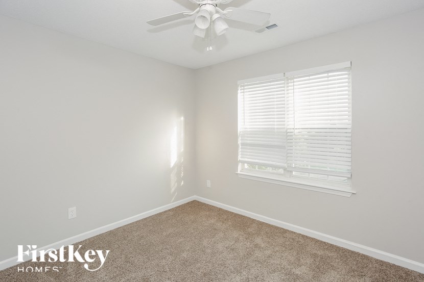 a bedroom with a ceiling fan and a window