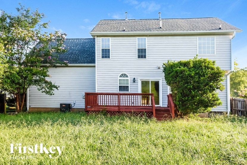 a wooden bench in front of a white house