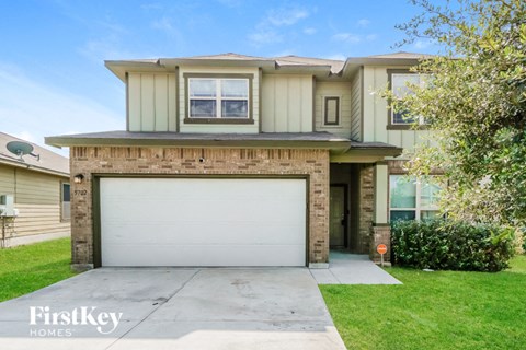 a house with a white garage door in front of a lawn