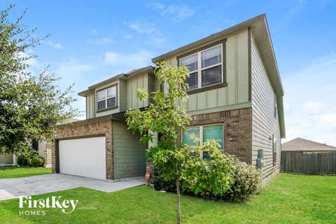 a green and brown house with a garage