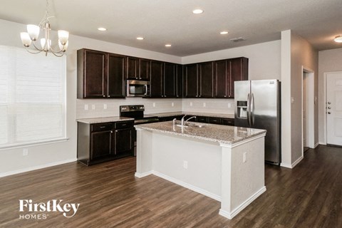 a kitchen with an island and a stainless steel refrigerator