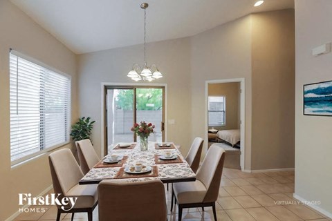 A dining room with a table set for six people.