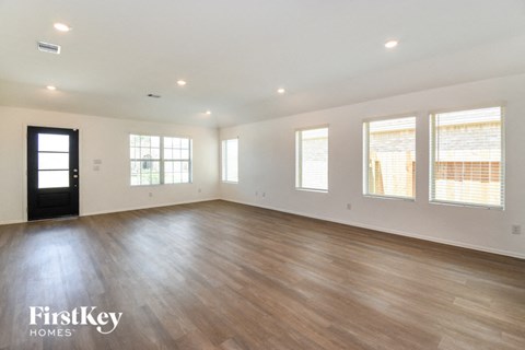 the living room of a new home with wood floors and white walls