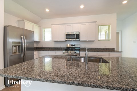a kitchen with granite counter tops and stainless steel appliances