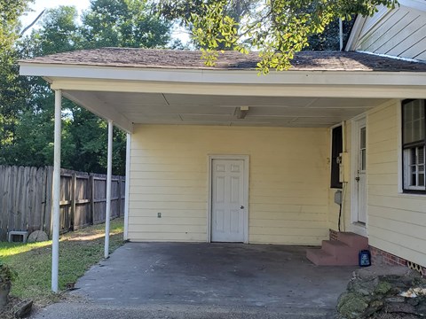 A small house with a white door and a porch.