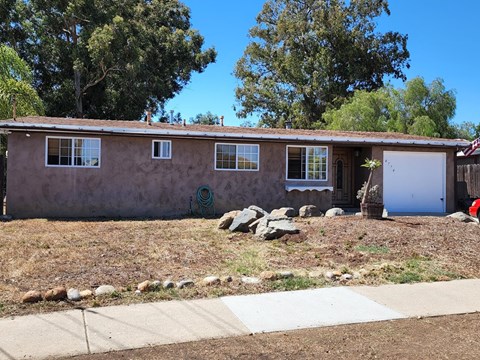 A house with a brown stucco exterior and a white garage door.