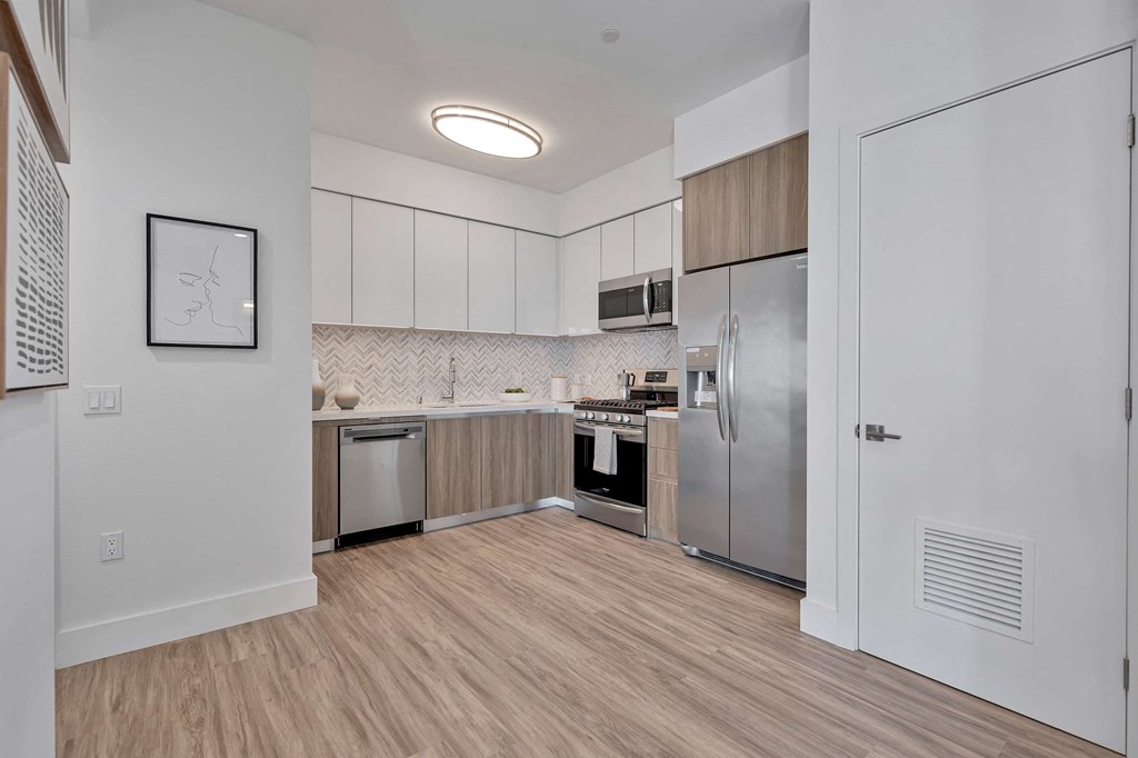 a kitchen with stainless steel appliances and wood flooring