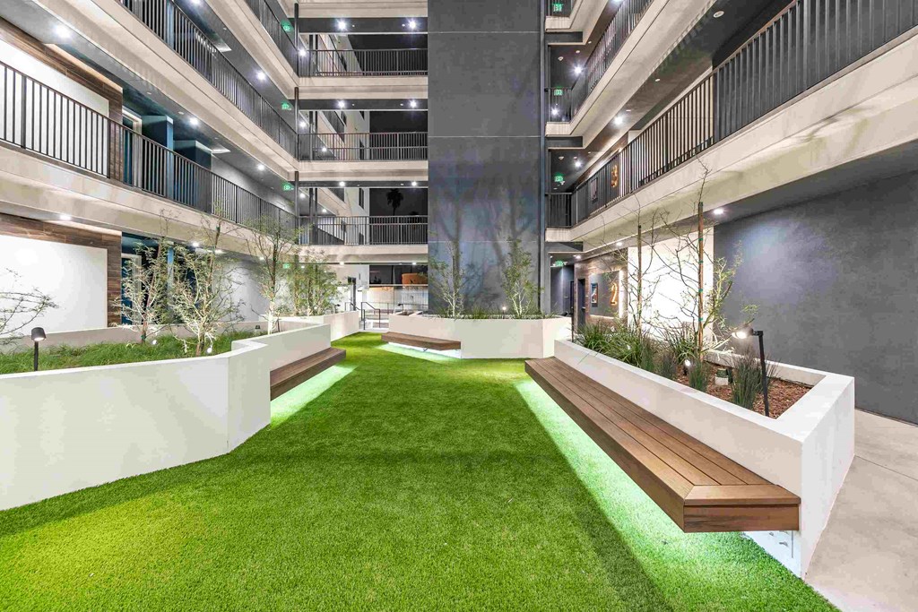 a courtyard in a building with grass and plants