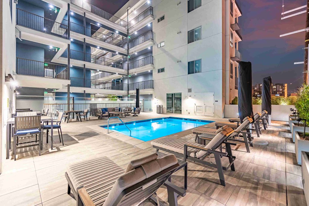 a swimming pool in front of an apartment building at night