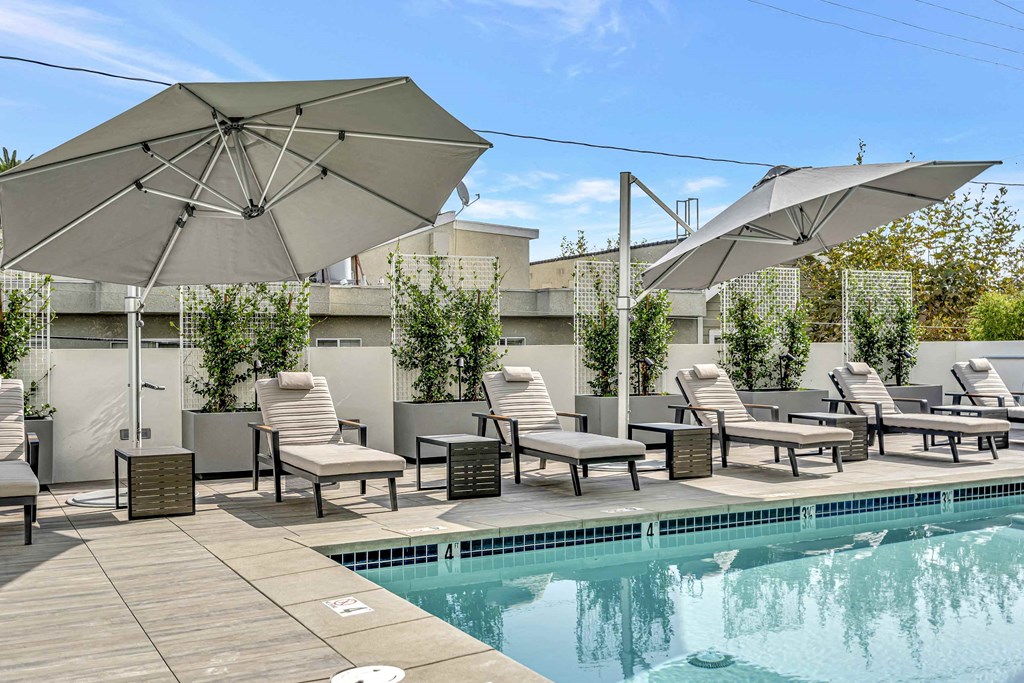 a swimming pool with umbrellas and chairs around it